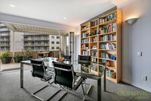 une bibliothèque avec une table et des chaises en verre dans l'établissement QV Downtown Executive Penthouse Parking Wifi - 782, à Auckland