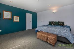 a bedroom with a bed and a blue wall at QV Stays Stunning Downtown Executive Penthouse in Auckland