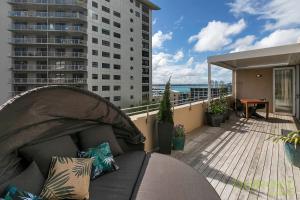 - un canapé sur le balcon d'un immeuble dans l'établissement QV Downtown Executive Penthouse Parking Wifi - 782, à Auckland