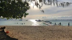 a beach with people and boats in the water at Sulu Plaza in Boracay