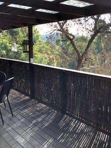 a wooden deck with a table and a chair on it at The Green Room Wattle Glen in Wattleglen