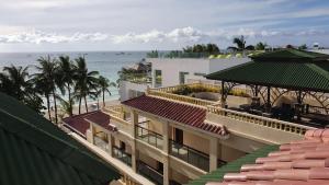 um edifício na praia com o oceano ao fundo em Golden Phoenix Hotel Boracay em Boracay