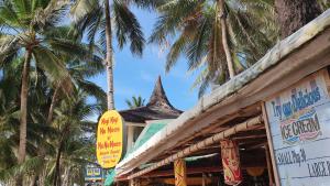 長灘島的住宿－尼吉尼吉努諾斯努努諾斯，商店前有棕榈树的建筑