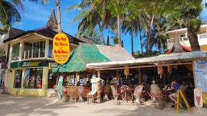 a restaurant with tables and chairs and palm trees at Nigi Nigi Nu Noos 'e' Nu Nu Noos in Boracay