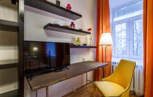 a living room with a television and a yellow chair at Апартаменты на Тверской in Moscow