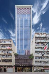 een hoog gebouw met veel ramen bij Lumine Hotel in Hong Kong