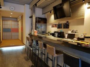 a restaurant with a bar with stools at Guest House Rice Chikko in Osaka