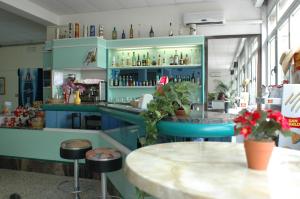 a restaurant with blue cabinets and a counter with stools at Villaggio Accademia in Cesenatico