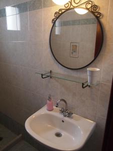 a bathroom with a sink and a mirror at To Petrino in Koufonisia