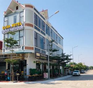 a large white building on a city street with a car at Elisa Hotel in Ninh Binh