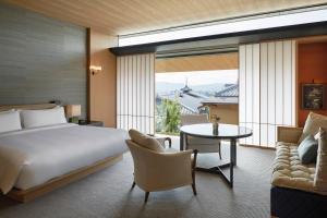 a bedroom with a bed and a table and a couch at Park Hyatt Kyoto in Kyoto