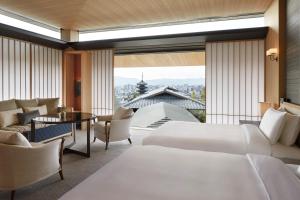 a hotel room with two beds and a large window at Park Hyatt Kyoto in Kyoto