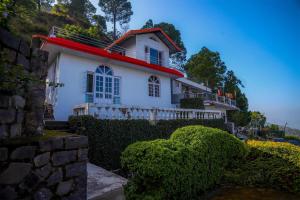 a white house with a red roof at Misty Mountains Cottage - In the Lap of Nature! in Kasauli