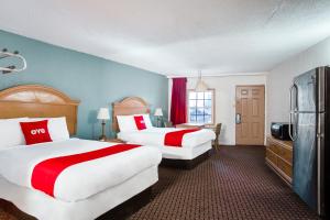 Habitación de hotel con 2 camas y nevera. en OYO Hotel Bald Knob near Searcy AR, en Bald Knob