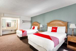 a hotel room with two beds with red and white pillows at OYO Hotel Bald Knob near Searcy AR in Bald Knob