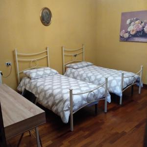 a room with two beds and a table at B&B Cascina Baraggione in Granozzo con Monticello