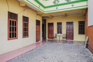 un patio vacío de una casa con puertas de madera en RedDoorz Syariah near Stadion Maulana Yusuf, en Serang