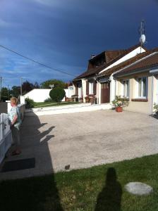 a woman standing next to a fence in front of a house at Baie de somme in Pendé +5 photos