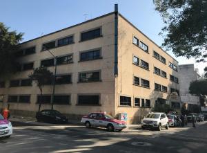 a large building with cars parked in front of it at Hotel Conde Alameda CDMX in Mexico City