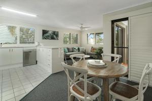 uma cozinha e sala de estar com mesa e cadeiras em Riverside location, Noosa Sound em Noosa Heads