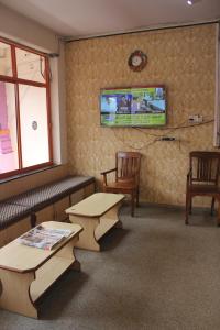 Dod BallāpurにあるSantosh Lodgeのテーブル2台と椅子2脚付きの待合室