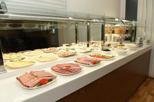 a buffet with many plates of food on a table at Hotel Olive Inn in Aschaffenburg