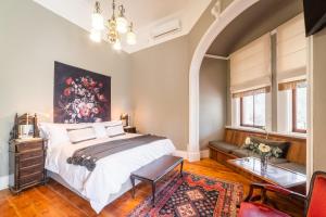 1 dormitorio con 1 cama con una pintura en la pared en Welgeluk Feather Palace en Oudtshoorn