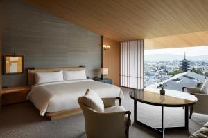 a hotel room with a bed and a table and chairs at Park Hyatt Kyoto in Kyoto