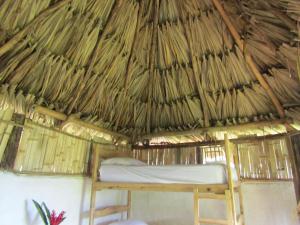 1 cama en una cabaña con techo de paja y colchón en Reserva Atashi en La Poza