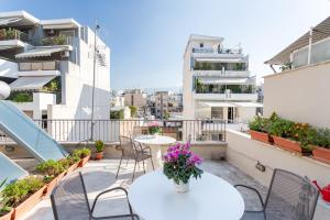 - un balcon avec des tables et des chaises dans un bâtiment dans l'établissement Acropolis Suites - Where else in Athens?, à Athènes