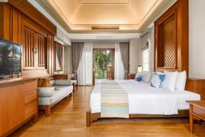 Fair House Villas & Spa, Koh Samui في شاطئ مينام: غرفة نوم بسرير ابيض كبير وتلفزيون