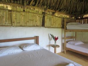 ein Schlafzimmer mit einem Bett, einem Etagenbett und einem Regal in der Unterkunft Reserva Atashi in La Poza