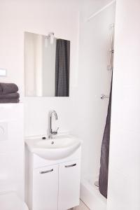 a white bathroom with a sink and a mirror at Ferienwohnungen BECKENDORF Schiller in Losheim +18 photos