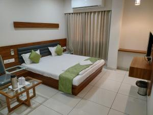 KalolHOTEL SATKAR CHHATRAL的卧室里有一张床和一台电视机 更多29张照片