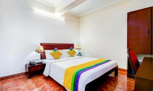 um quarto com uma cama grande e um cobertor colorido em Itsy By Treebo - Ammu Regency em Thrissur