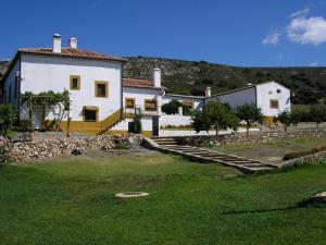 une grande maison blanche avec une colline en arrière-plan dans l'établissement Palacio Viejo de Las Corchuelas, à Torrejón el Rubio