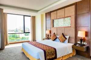 a bedroom with a large bed and a large window at Muong Thanh Holiday Quang Binh Hotel in Dong Hoi