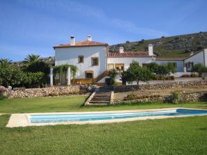 a house with a swimming pool in front of a yard at Palacio Viejo de Las Corchuelas in Torrejón el Rubio