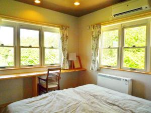 a bedroom with a bed and two windows at Hotel Resort Inn Niseko in Niseko