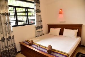 Un pat sau paturi într-o cameră la Hikkaduwa Beach House