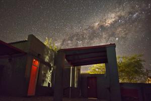 a starry night with a building and the milky way at The Ibis Lounge in Nieu-Bethesda