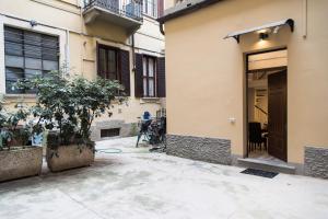 een gebouw met een deur en een boom op een binnenplaats bij YouHosty - Ariberto 22 in Milaan