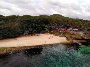 an aerial view of a beach with people in the water at 1peace beach resort in Anda