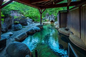 a pool of water with rocks in front of a building at Furusato in Takayama