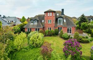 a large red brick house with a yard at Ferienwohnung im Poolhaus mit Ostseeblick in Wittenbeck