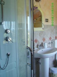 y baño con ducha y lavamanos. en Villa Asinara, en Platamona