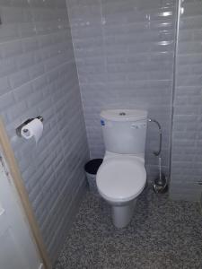 La salle de bains est pourvue de toilettes et d'un rouleau de papier toilette. dans l'établissement Pension Safari, à Tanger