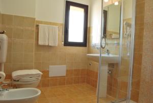 La salle de bains est pourvue de toilettes, d'un lavabo et d'une douche. dans l'établissement Case Vacanze Anni 20, à Bagheria