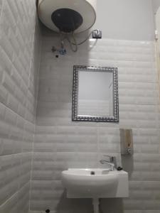 ein Bad mit einem Waschbecken und einem Spiegel in der Unterkunft Pension Safari in Tangier