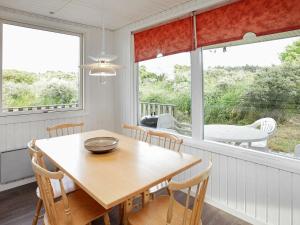 a dining room with a table and chairs and a window at 8 person holiday home in Hj rring in Hjørring